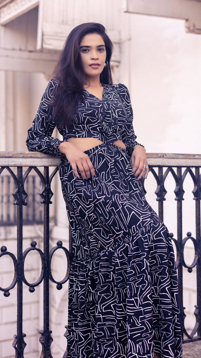 Mastering the First Impression: Your intriguing post title goes here Woman in patterned dress leaning on ornate railing in an elegant urban setting.